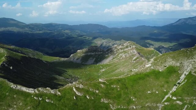 Aerial view of green mountain valley bowl and limestoe cliffs