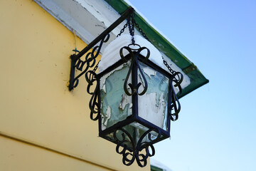 Old Wrought Iron Lantern with Snow on a Yellow Building