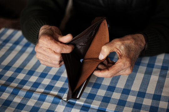 An empty wallet or with very little money in the hands of an old man.