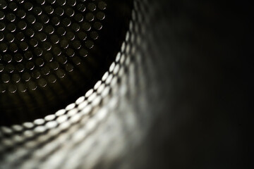 Edge light on perforated metal tubes abstract