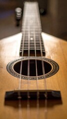 Obraz premium Close up perspective of a wooden ukulele instrument showing strings tuning pegs and sound hole with decorative inlay in warm lighting