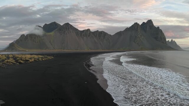 Iconic Vestrahorn mountain and black sand beach at suset