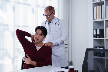Doctor examining a young male patient with back and shoulder pain during a physical therapy consultation, representing healthcare, diagnosis, and treatment for musculoskeletal issues in a clinic