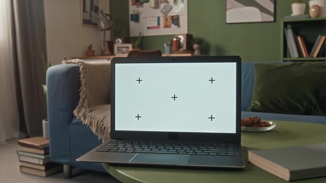 Close up shot of laptop with blank mockup screen placed on coffee table in cozy living room, remote worker setup in flexible home workspace
