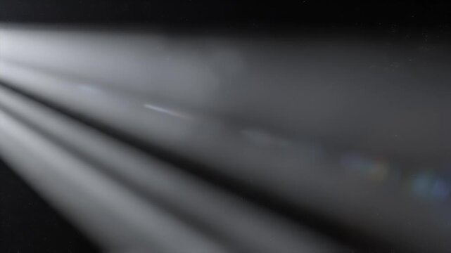 Blurry abstract background with light rays and dark shadows.