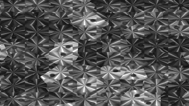 Close-up of a metallic surface with a repeating pattern of raised, star-shaped designs in shades of gray and black, with a reflective texture.