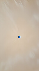Small Blue Object in Beige Background
