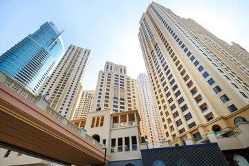 Fototapeta premium Urban architecture and high-rise buildings reaching for a clear blue sky.