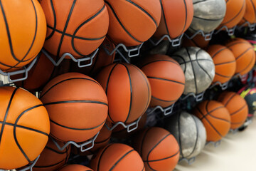 Obraz premium Many basketballs on rack in a shop. Sport equipment store with many balls.