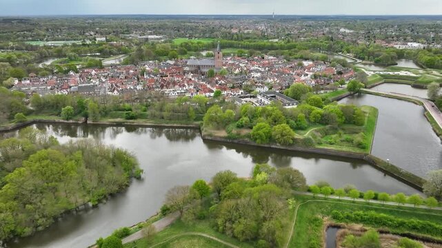 Aerial footage of historic fortified town of Naarden in the Netherlands with its distinctive star-shaped defensive walls, canals and moat encircling the old town.