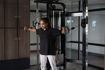 Woman performing chest fly exercise on cable crossover machine