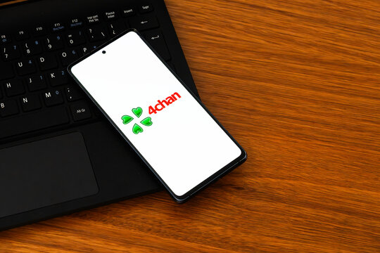 Punta Arenas, Chile &ndash; February 04, 2026: Iconic green four-leaf clover logo of 4chan displayed on a mobile phone screen resting on a laptop