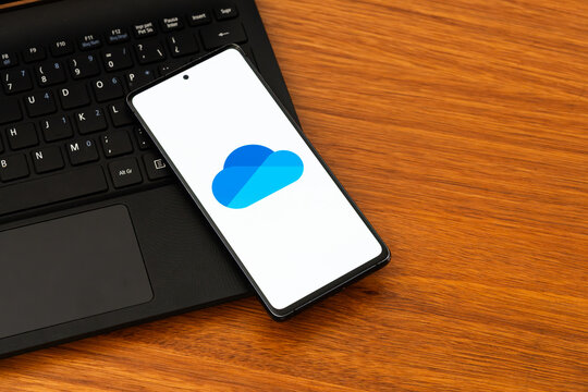 Punta Arenas, Chile &ndash; February 04, 2026: Refreshed Microsoft OneDrive "Fluid" cloud logo on a mobile phone resting on a laptop
