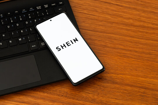 Punta Arenas, Chile &ndash; February 04, 2026: Iconic  Shein wordmark logo on a mobile phone screen resting on a laptop