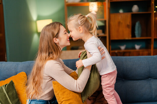 Mother and daughter sharing a loving moment, bonding at home in living room