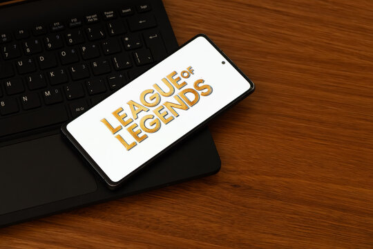 Punta Arenas, Chile &ndash; February 04, 2026: Close-up of a smartphone screen showing the League of Legends wordmark logo, positioned on a computer keyboard and wooden desk