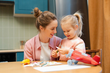 Mother and daughter enjoying creative crafting activity together at home