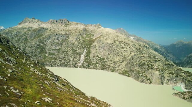 Aerial view of Lake Grimsel with water dam and snowy rocky mountains in Swiss