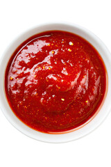 Close-up overhead view of a white bowl filled with vibrant red chili sauce, richly textured with spices