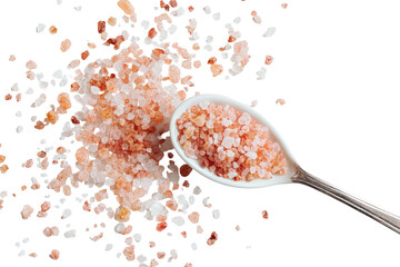 Top-down view of coarse pink crystal salt scattered on a dark surface, with some in a white spoon