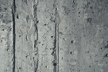 Obraz premium Front view of architectural concrete wall with vertical formwork lines and small pockmarks. Industrial cement texture with linear shuttering patterns for modern loft design and mockups.