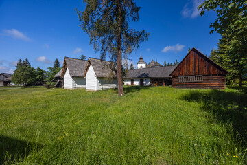 Historic folk buildings and a church in a green open air museum