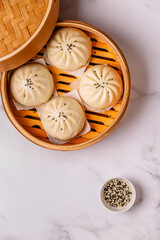 Steamed buns in bamboo steamer on a kitchen counter