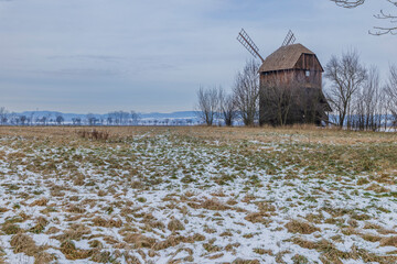 Traditional wooden windmill standing in a winter field