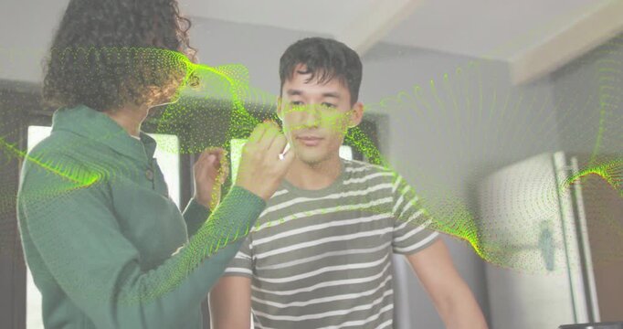 Non-binary offering red sample for taste test, feeding him by counter, green overlay sweeping