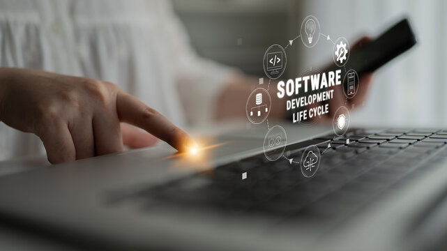 Close-up View of Hands Using Laptop to Illustrate Software Development Life Cycle with Creative Graphic Elements on Screen Quark.