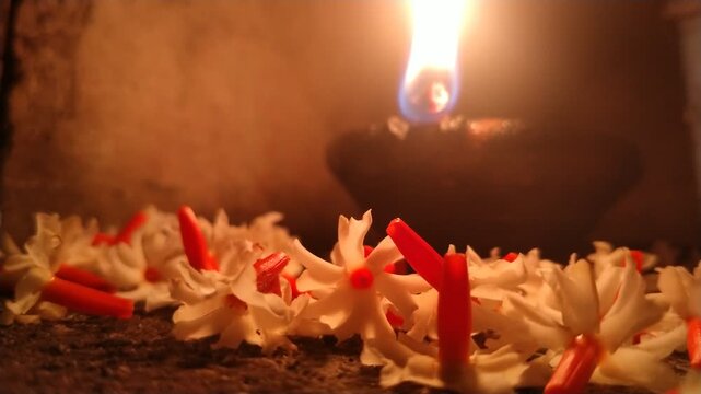 Traditional Oil Lamp with Night Jasmine Flowers Burning in Dark Spiritual Background