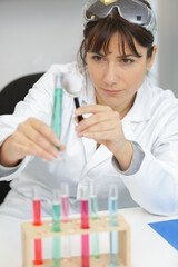 Fototapeta premium woman using a magnifying glass to look into pipette