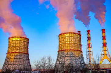 Industrial Power Plant with Smoking Chimneys Against a Blue Sky