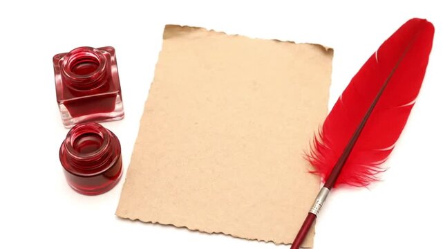 Vintage writing setup with blank paper and red feather quill