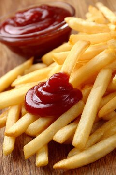 A plate of french fries with ketchup on top