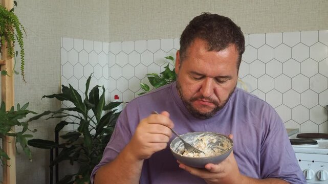 a grown man is having lunch in the kitchen