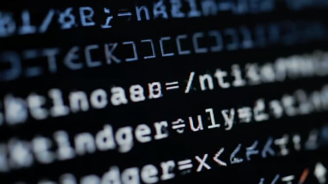Extreme close-up video: bright white programming code appearing on a deep black digital screen with a blinking cursor, displaying intricate data processing. Concept of digital technology