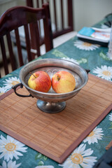 Two Red and Yellow Apples in Silver Vase on Table in the Kitchen.