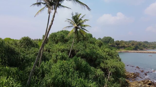 A top view of the sandy isthmus between the island and the mainland. The Blue Island, located at the southern tip of Sri Lanka, is becoming an increasingly popular tourist destination. A tropical dron