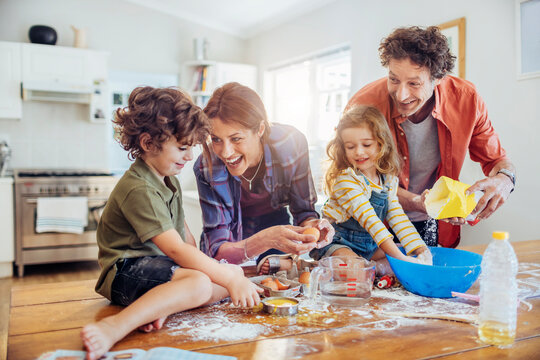 Happy family baking together in home kitchen