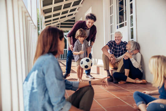 Multi-generational family relaxing and playing on home porch