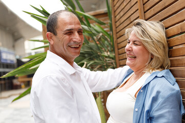 A middle-aged couple, husband and wife, enjoy each other's company during a walk in the park.