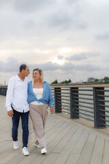 A middle-aged couple, husband and wife, enjoy each other's company during a walk in the park.
