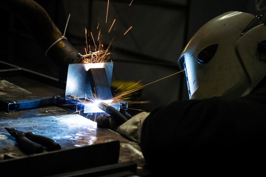 Industrial steel welding with SMAW process and sparks flying
