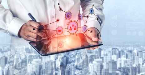 A business professional engages with a digital tablet, analyzing data and managing information systems against a backdrop of an urban skyline, symbolizing innovation. Tessel © InfiniteFlow