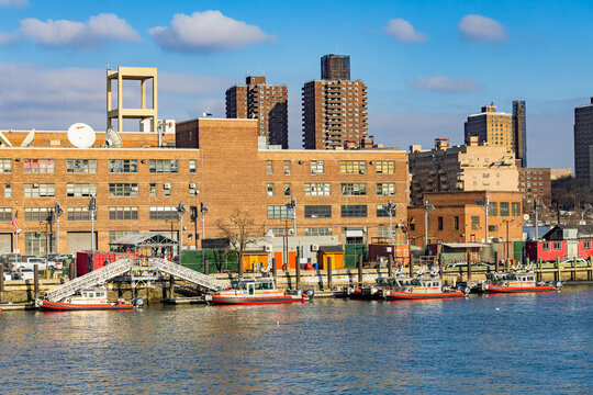 New-York, USA - 15.01.2026: FDNY fireboats docked along the waterfront near industrial buildings and apartment towers in New York City