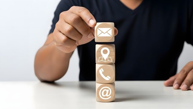 Person stacking wooden blocks with communication icons that represent different contact methods