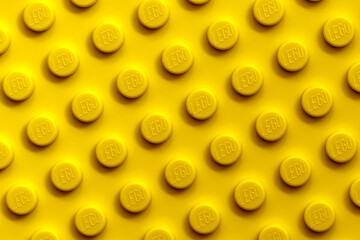 Fototapeta premium Vibrant Yellow LEGO Brick Surface Texture Background