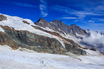 Fototapeta premium Mountain glacier panorama and summits Täschhorn, Dom and Nadelhorn (left to right) in summer in Swiss Alps, canton of Valais, Switzerland