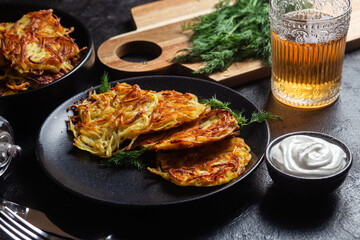 Golden Potato Pancakes with Sour Cream and Fresh Dill on a Dark Table